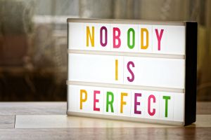 Eine Leuchttafel mit bunten Buchstaben zeigt den Schriftzug "Nobody is perfect".