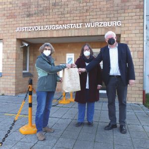 Monika Sodenkamp übergibt eine Weihnachtstüte von „draußen“ an die evangelische Gefängnisseelsorgerin Astrid Zeilinger und Anstaltsleiter Robert Hutter.