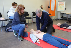 Ausbilderin Sabine Hofmann (links) betreut Generalvikar Dr. Jürgen Vorndran bei der Herz-Druck-Massage. 
