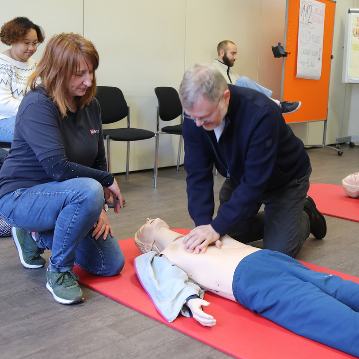 Ausbilderin Sabine Hofmann (links) betreut Generalvikar Dr. Jürgen Vorndran bei der Herz-Druck-Massage. 