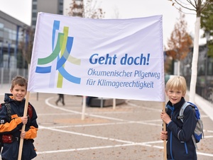 Kinder mit einem Transparent des Klimapilgerwegs